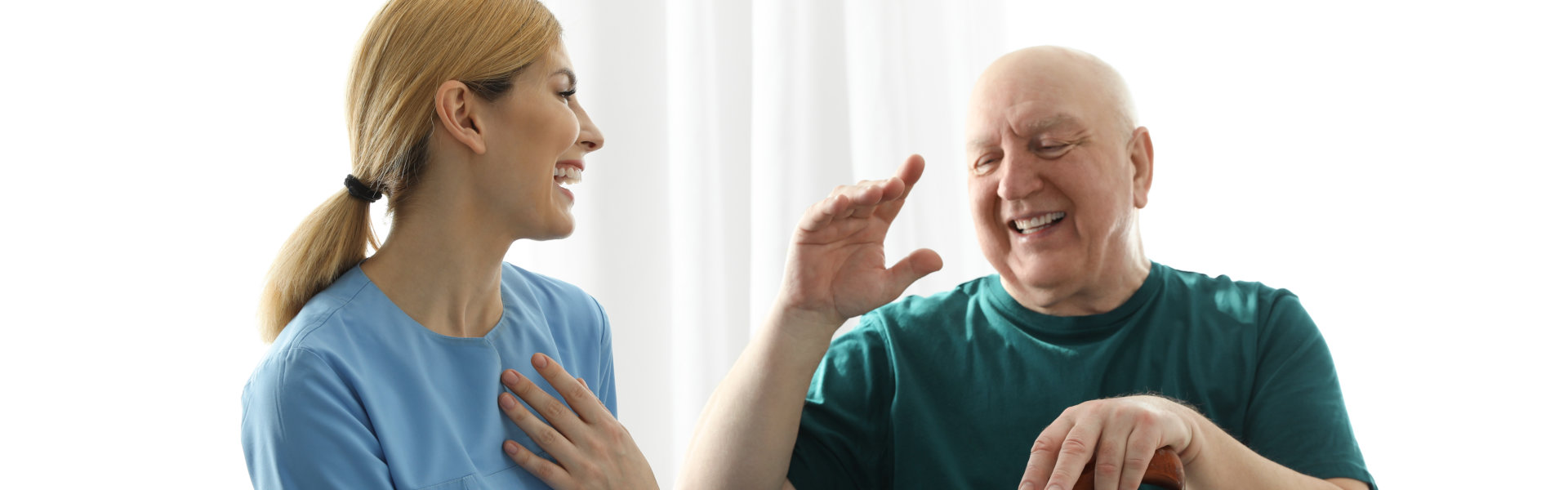 caregiver and elderly man having fun together