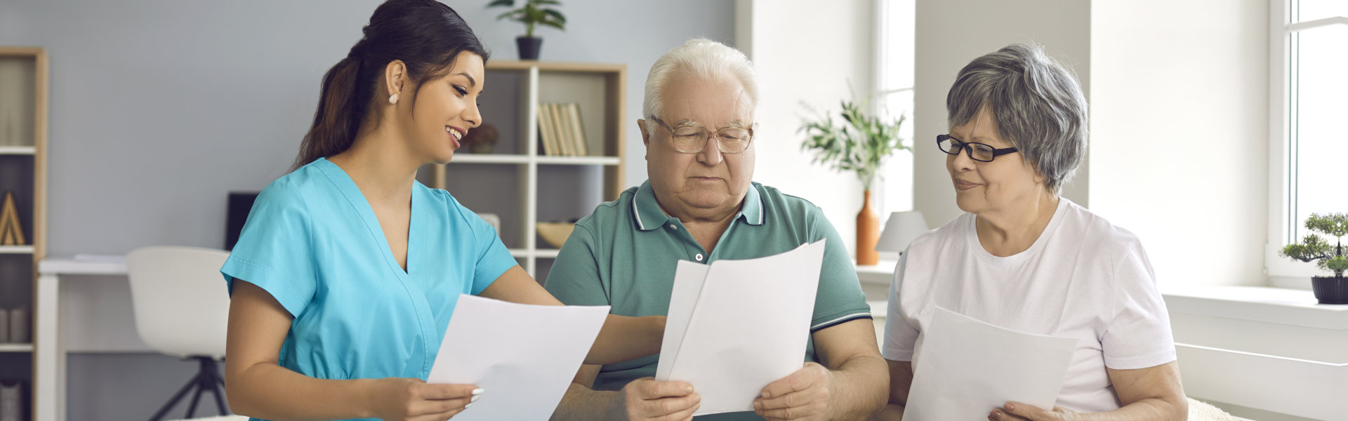 elderly couple and young carer holding a letter