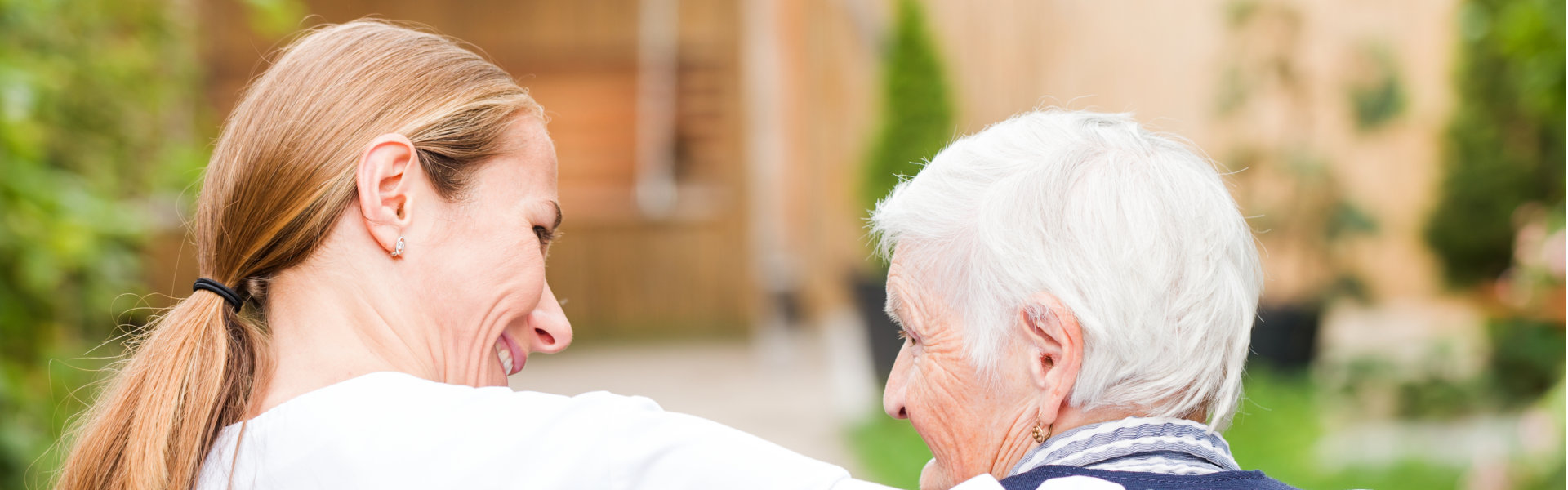 caregiver and elderly woman walking together